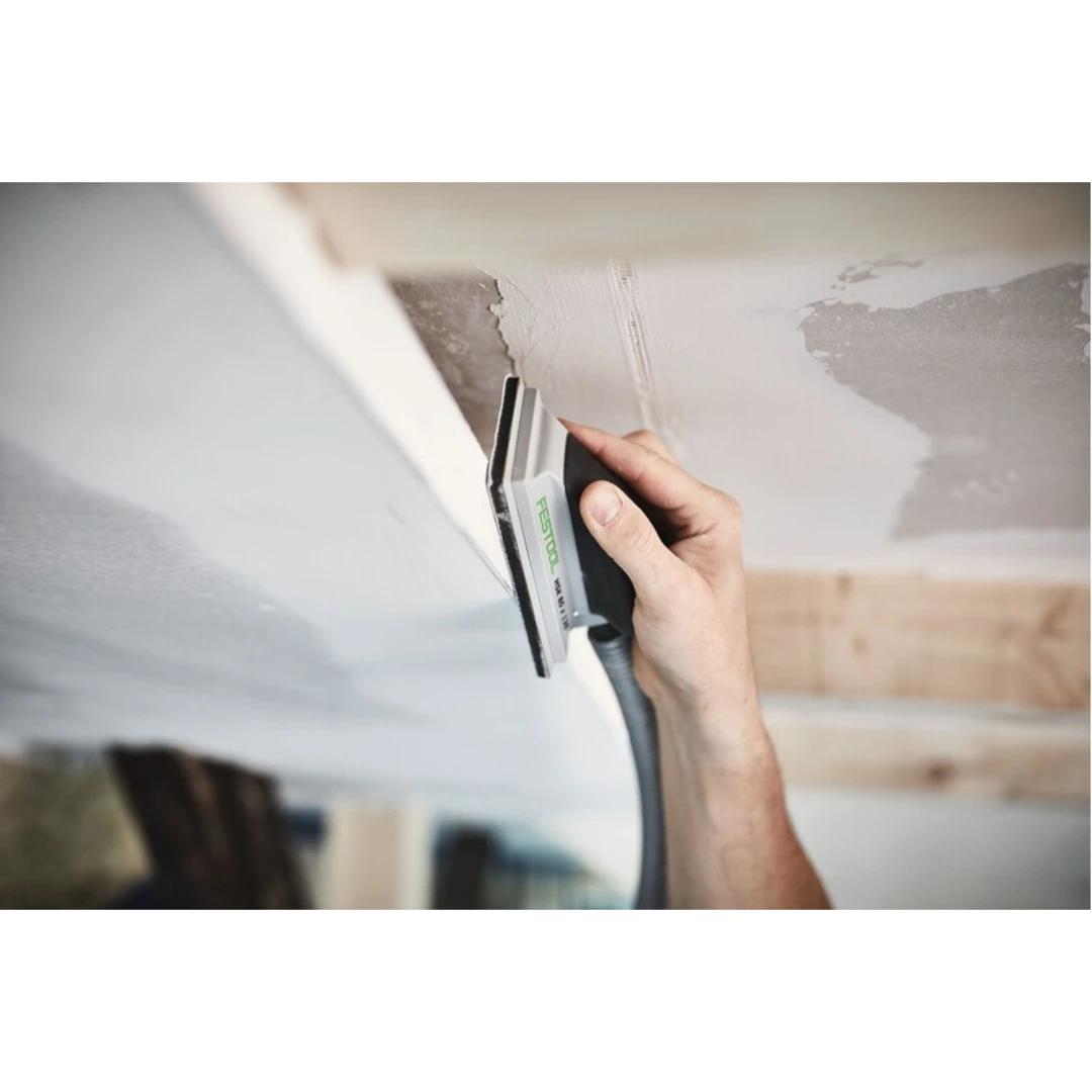 Hand sanding block with dust extraction used on drywall surface for smooth finishing in home improvement project