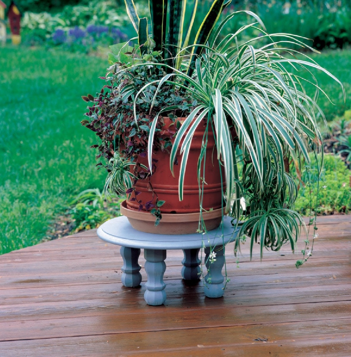 Small round wooden plant stand with turned legs on outdoor deck in home improvement furniture accessories