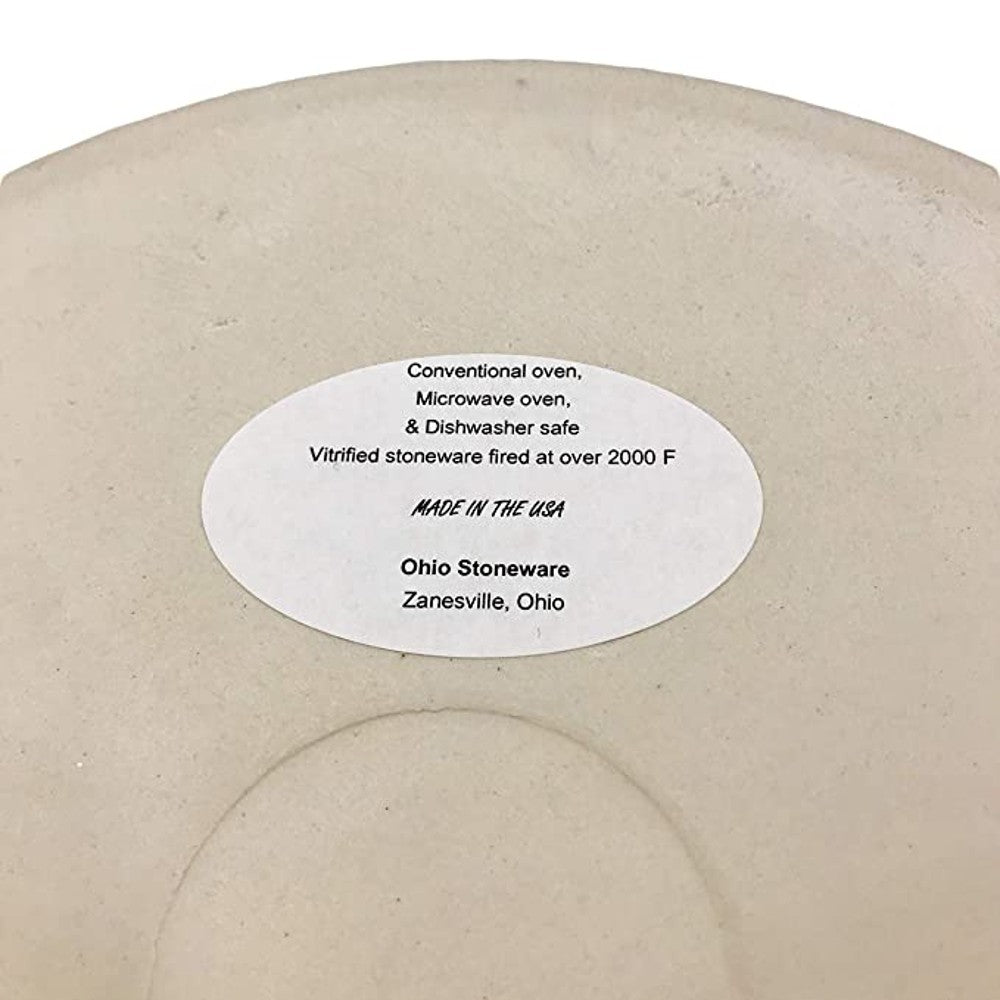 Bottom of cream-colored stoneware crock with label stating oven, microwave, and dishwasher safe, made in USA