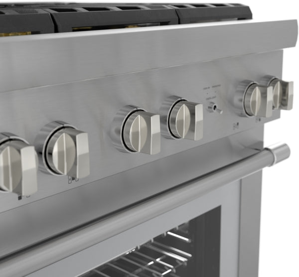 Close-up of stainless steel range control panel with six knobs and a sleek handle in a modern kitchen setting