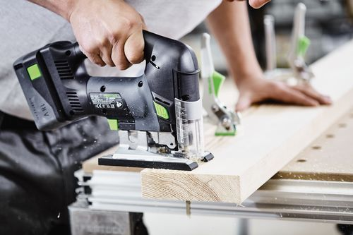 Battery powered cordless D-handle jigsaw cutting a wooden plank with clamps in a woodworking workshop setting