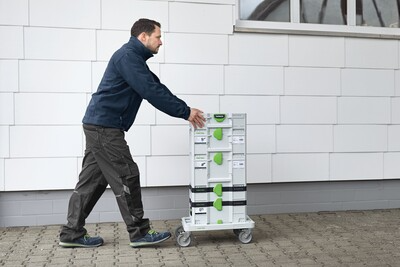 Person pushing wheeled cart stacked with modular tool storage boxes for workshop organization and tool storage accessories