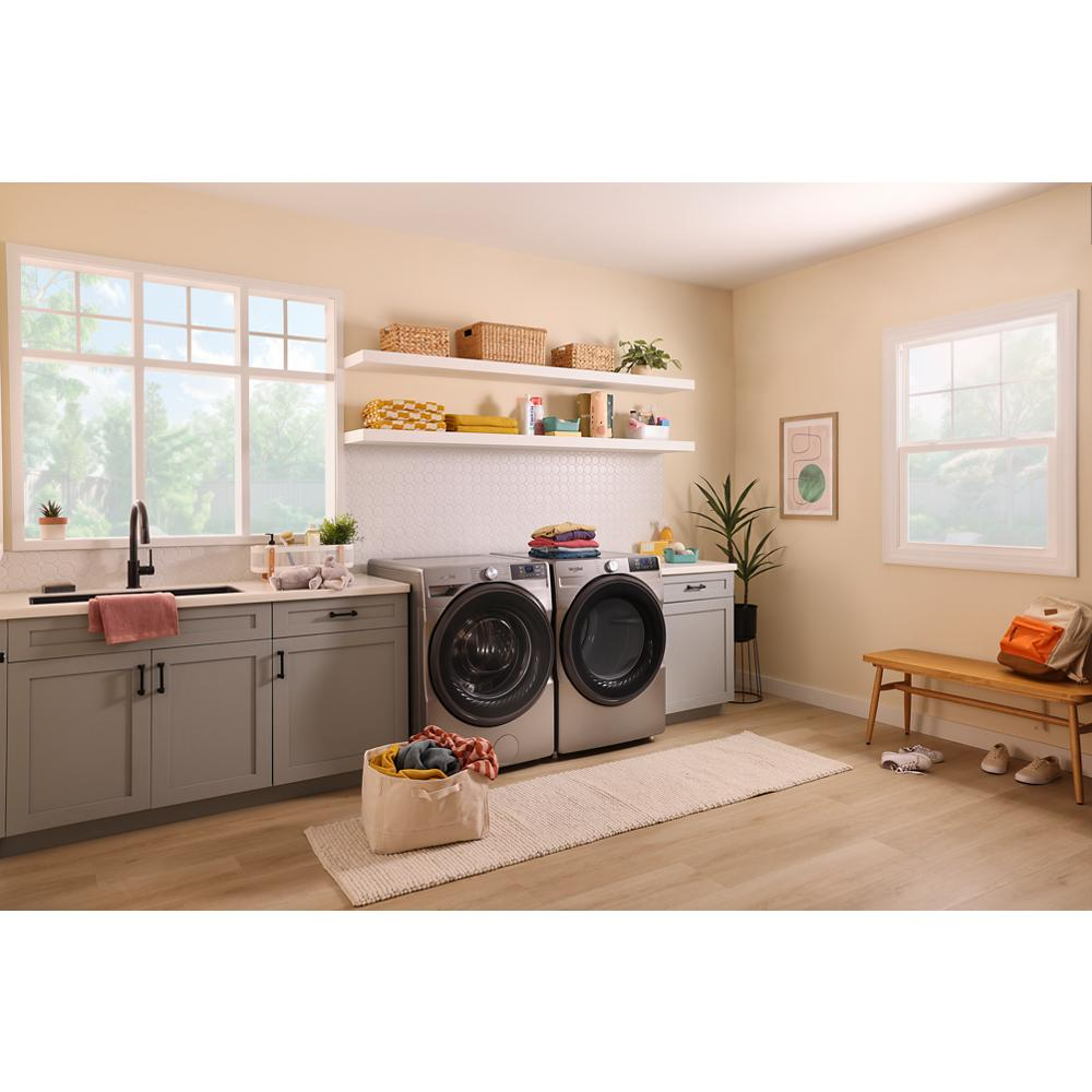 Stylish laundry room with smart front load electric washer and dryer in gray, featuring cabinetry and natural light from windows