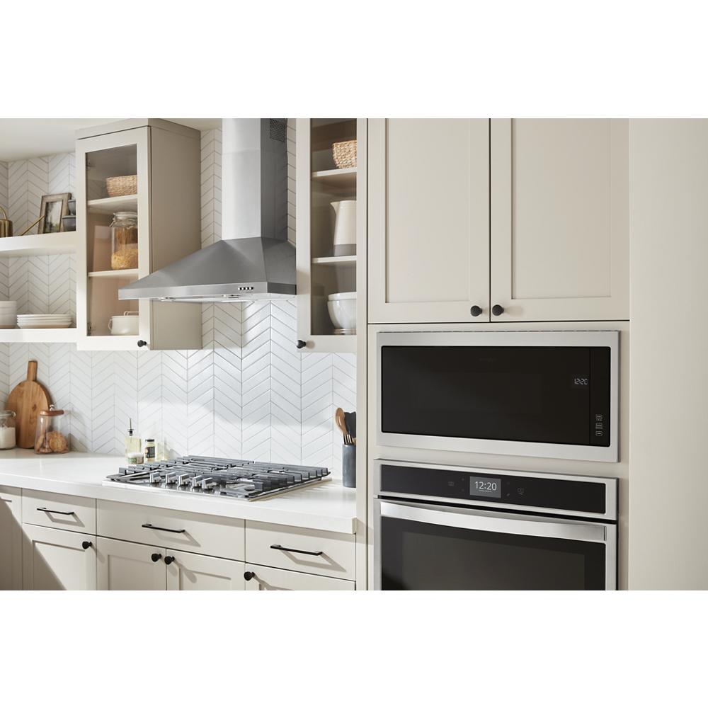 Built-in microwave with slim stainless steel trim integrated into light-colored kitchen cabinetry from Kitchen & Kitchenware collection