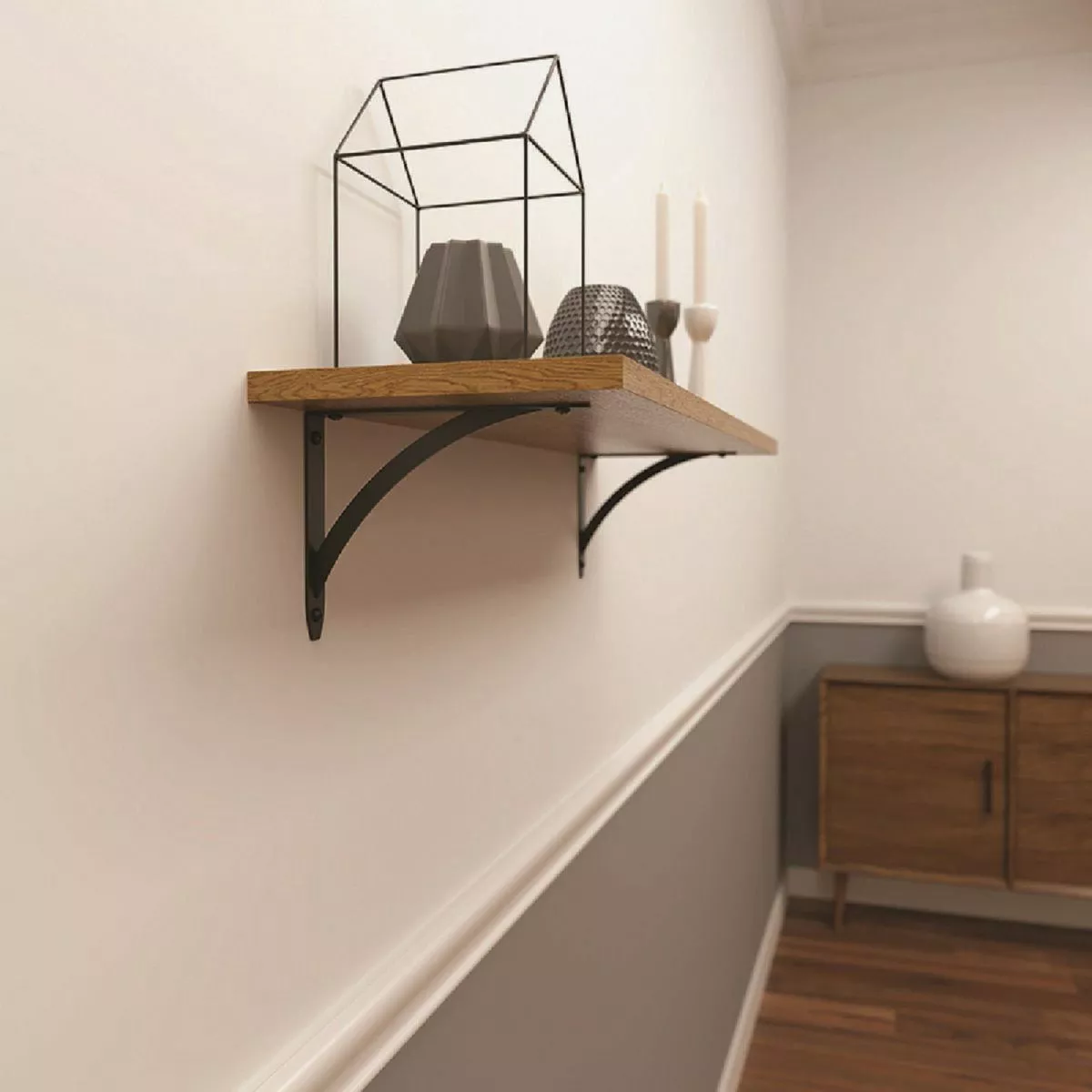 Black metal bracket with curved support holding wooden shelf displaying modern decor in home improvement setting
