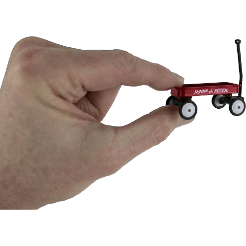 Hand holding miniature red Radio Flyer wagon showcasing its tiny size for collectible or display purposes