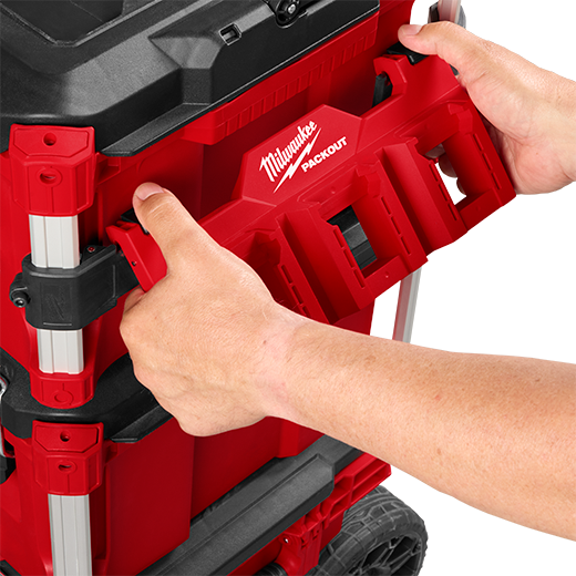 Hands attaching a red Milwaukee PACKOUT™ mount to secure and customize modular tool storage for workshop organization