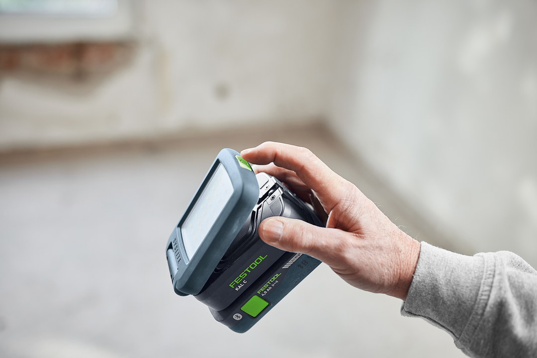 Hand holding cordless Festool Syslite task light with LED panel for home improvement and work lights under $100