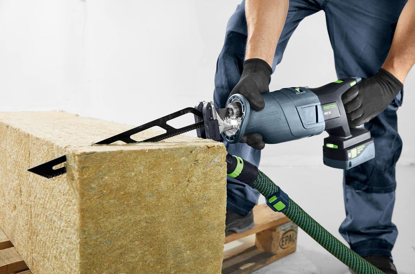 Professional cutting tool with sabre saw blade slicing through insulation material for home improvement use