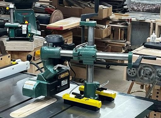 Green and yellow mount securing power feeder on cast iron saw table in tool and saw accessories collection
