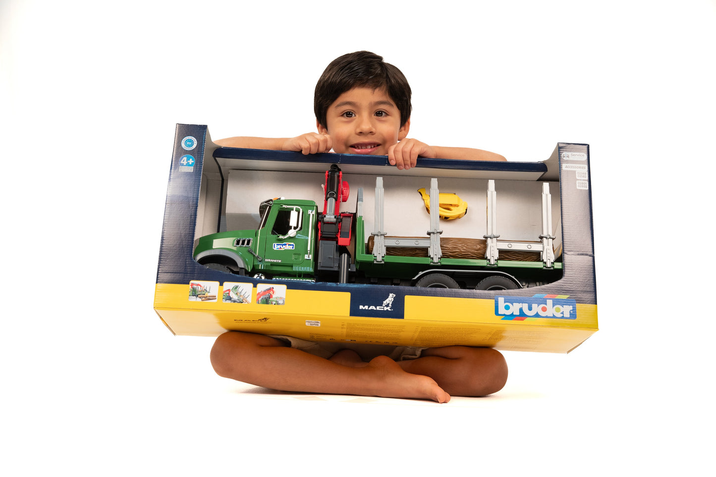 Child holding Bruder MACK Granite timber truck toy with red loading crane and logs in Toys & Games collection