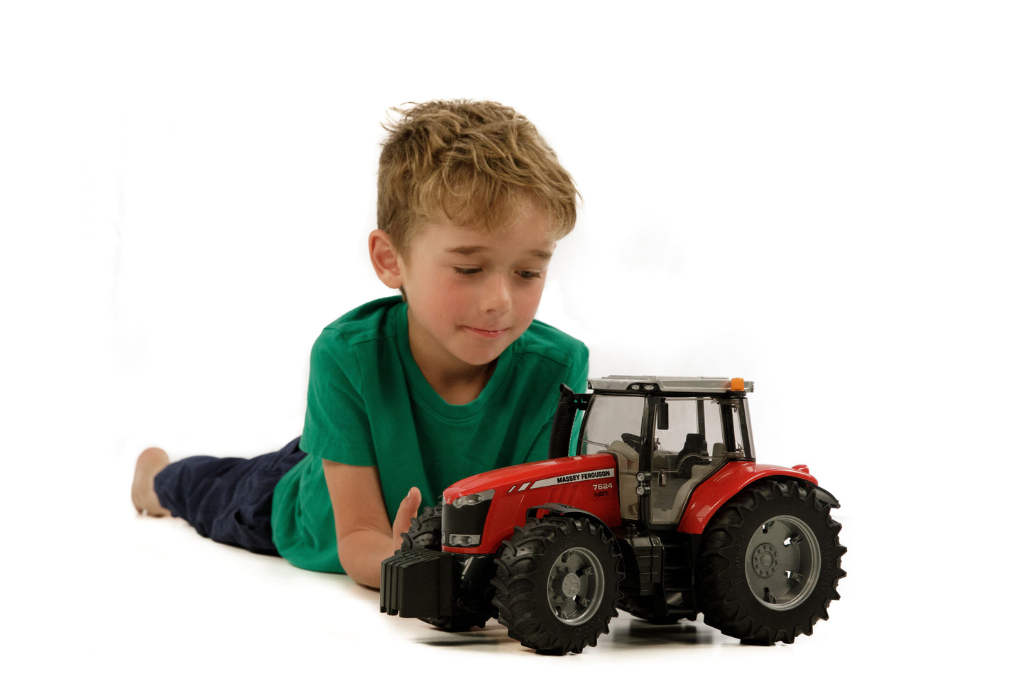 Child lying on floor playing with red Bruder Toys Massey Ferguson 7624 tractor in Vehicles & Remote Controlled Toys collection