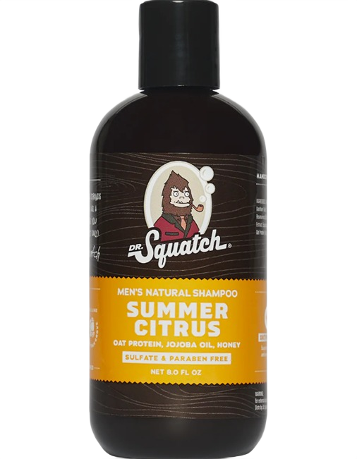Dark brown bottle of natural men's shampoo with bright orange label featuring citrus ingredients and branding design