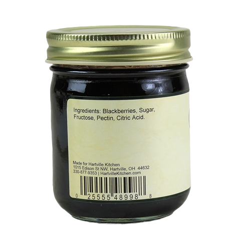 Glass jar of Hartville Kitchen seedless blackberry jam showing ingredients label and gold metal lid