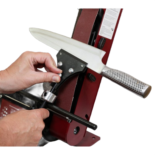 Hand adjusting sharpening jig on a belt sander to hone a kitchen knife blade for precise cutting tools maintenance