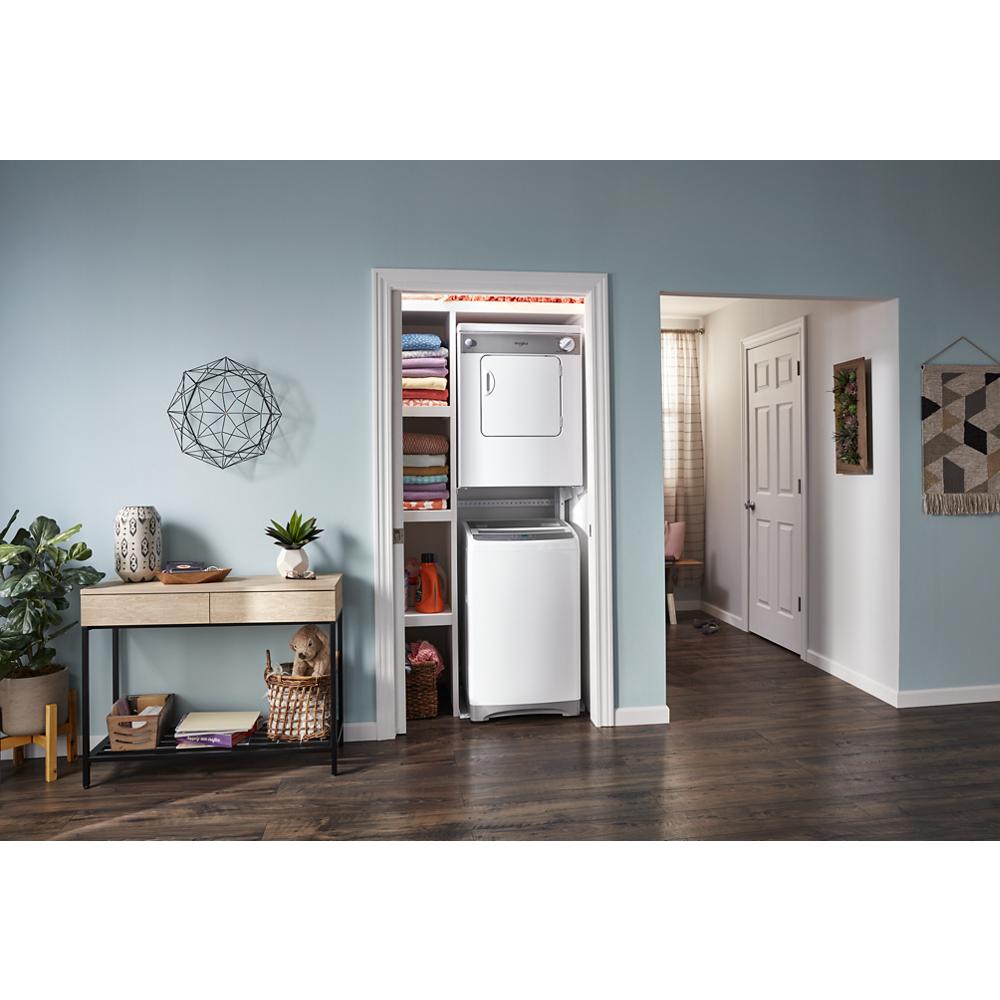 Compact white front load dryer stacked above matching washer in organized laundry closet with folded towels and home decor