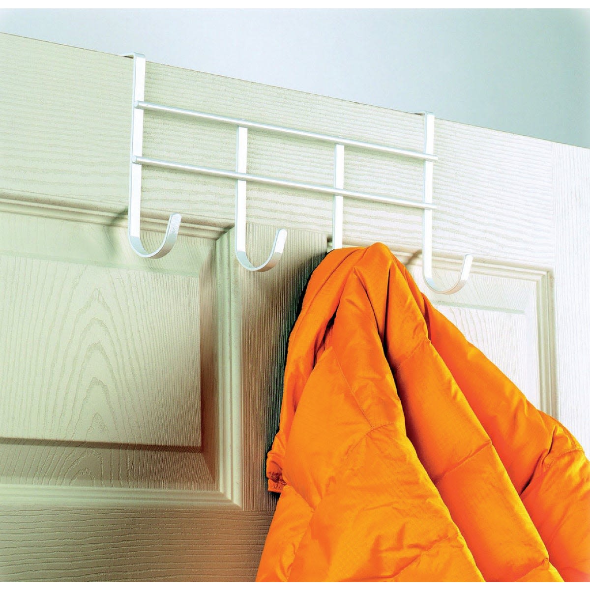 White over-the-door hook rail with four large hooks holding an orange jacket for home organization and improvement