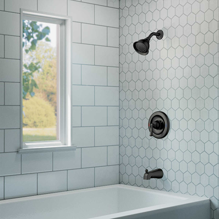 Matte black one-handle tub and shower faucet set installed on white hexagonal and rectangular tiled bathroom wall