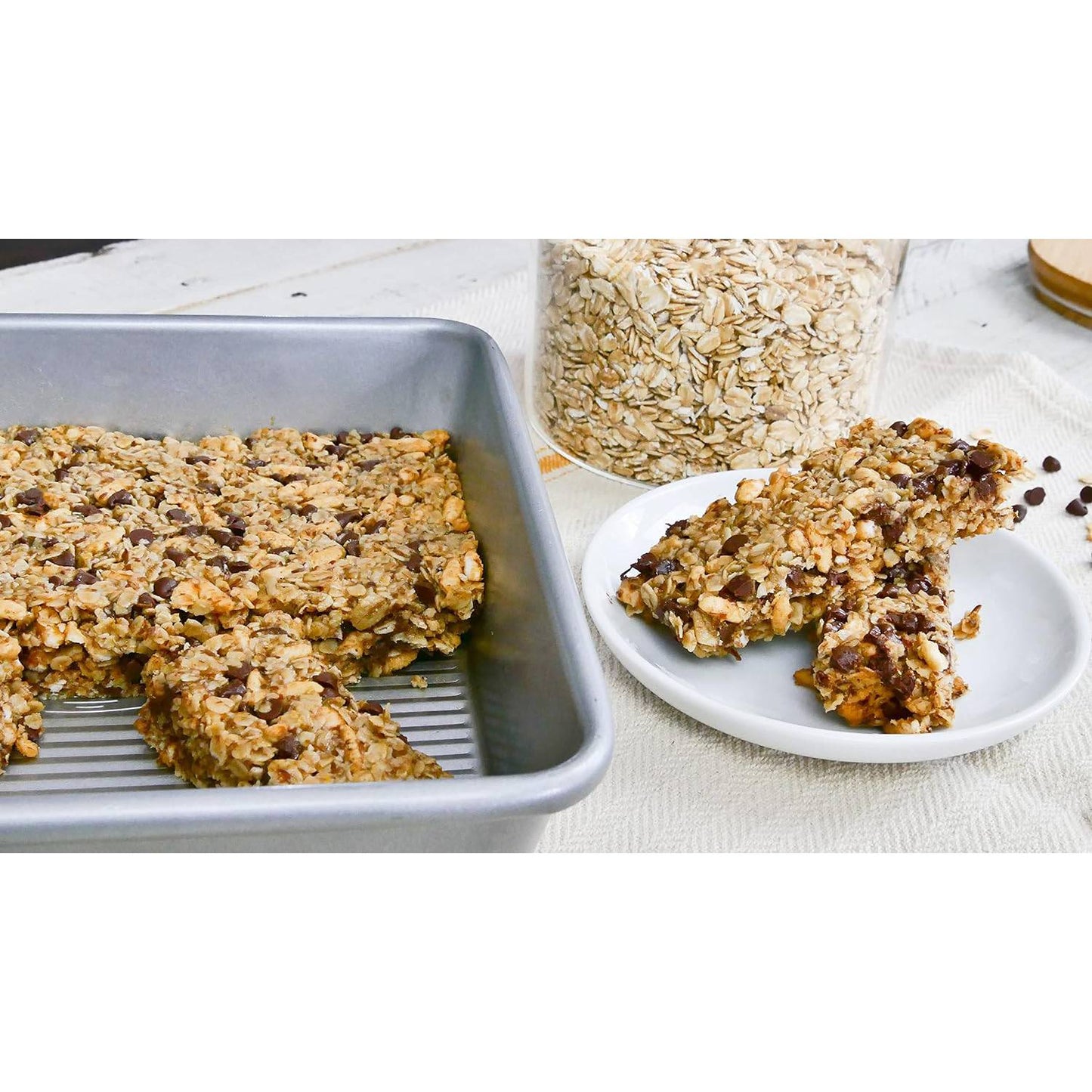 Silver rectangular cake pan with oat and chocolate chip bars on a white surface in kitchenware and bakeware collection