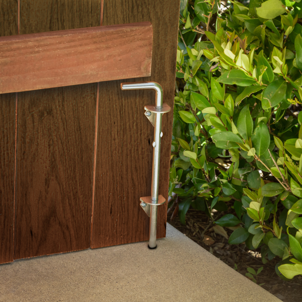 Zinc plated steel cane bolt installed on wooden gate securing it to concrete patio in door and gate accessories collections