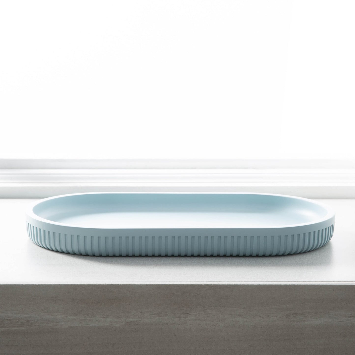 Light blue oval serving tray with textured edges, ideal for stylish home organization and decor displays