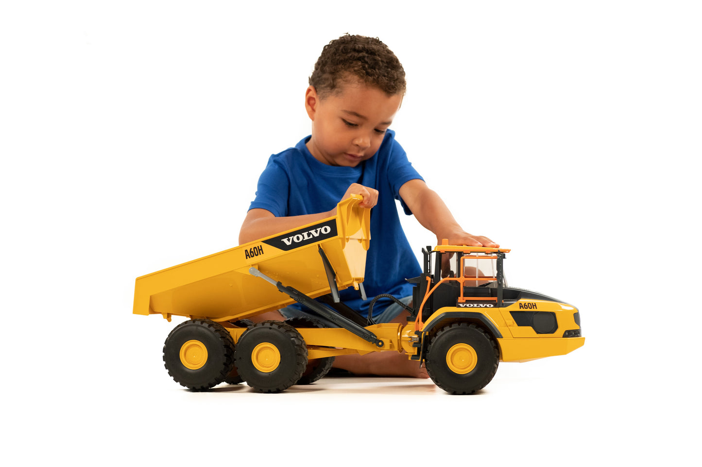Young child engaging with a detailed yellow Volvo A60H articulated hauler toy truck for imaginative play