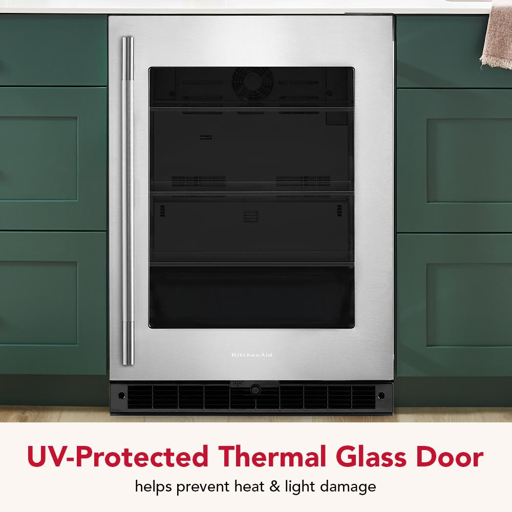 Undercounter refrigerator with stainless steel frame, UV-protected thermal glass door, and modern green cabinetry in kitchen