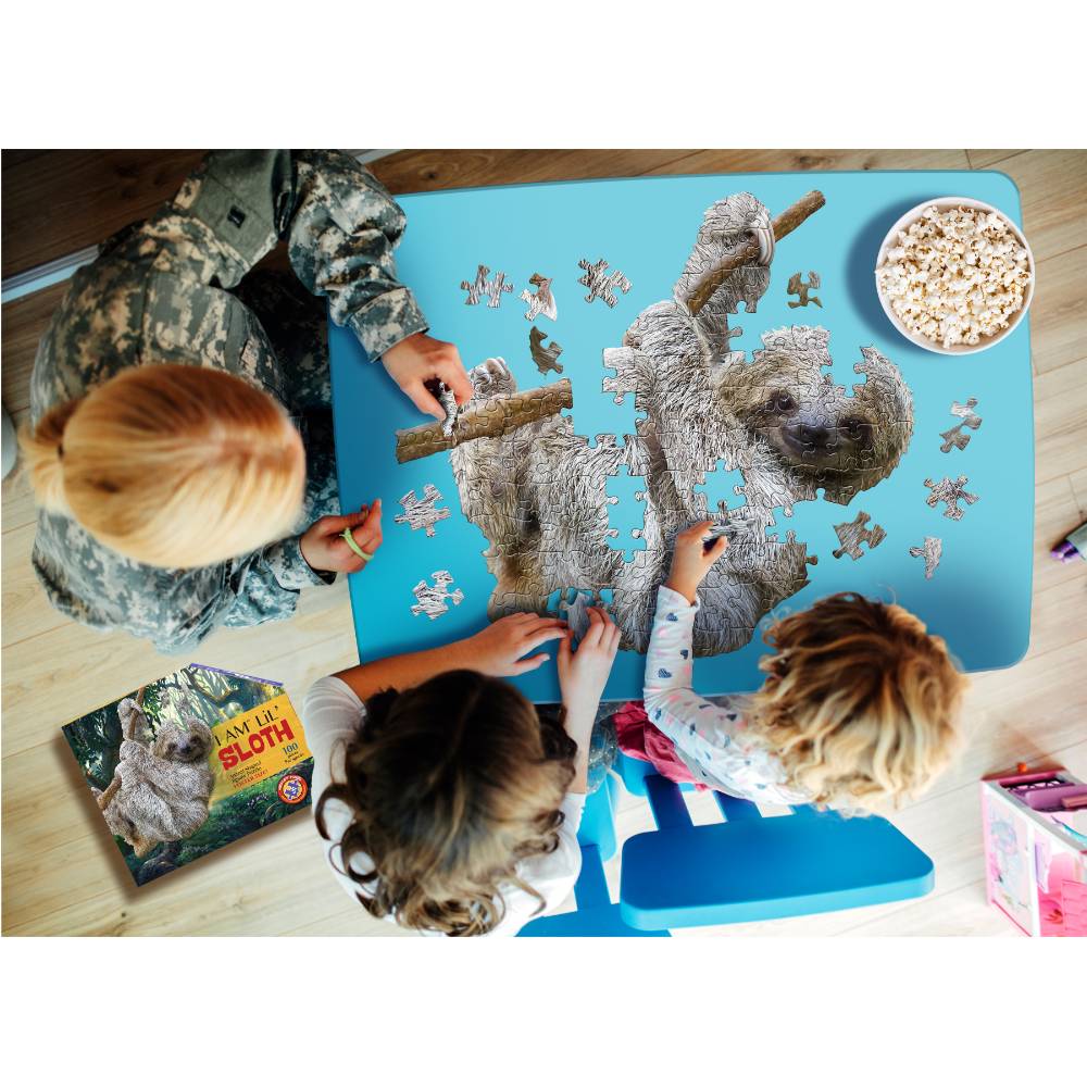 Children assembling an oversized sloth-shaped puzzle on a blue mat with popcorn nearby in toys and games collection