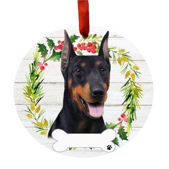 Round Christmas ornament with Doberman face in holiday wreath and personalized bone tag hanging by red ribbon