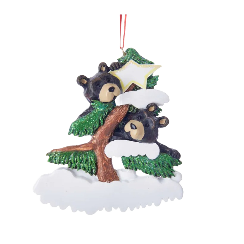 Two black bears peeking from snowy evergreen branches with a hanging loop and a star-shaped decoration