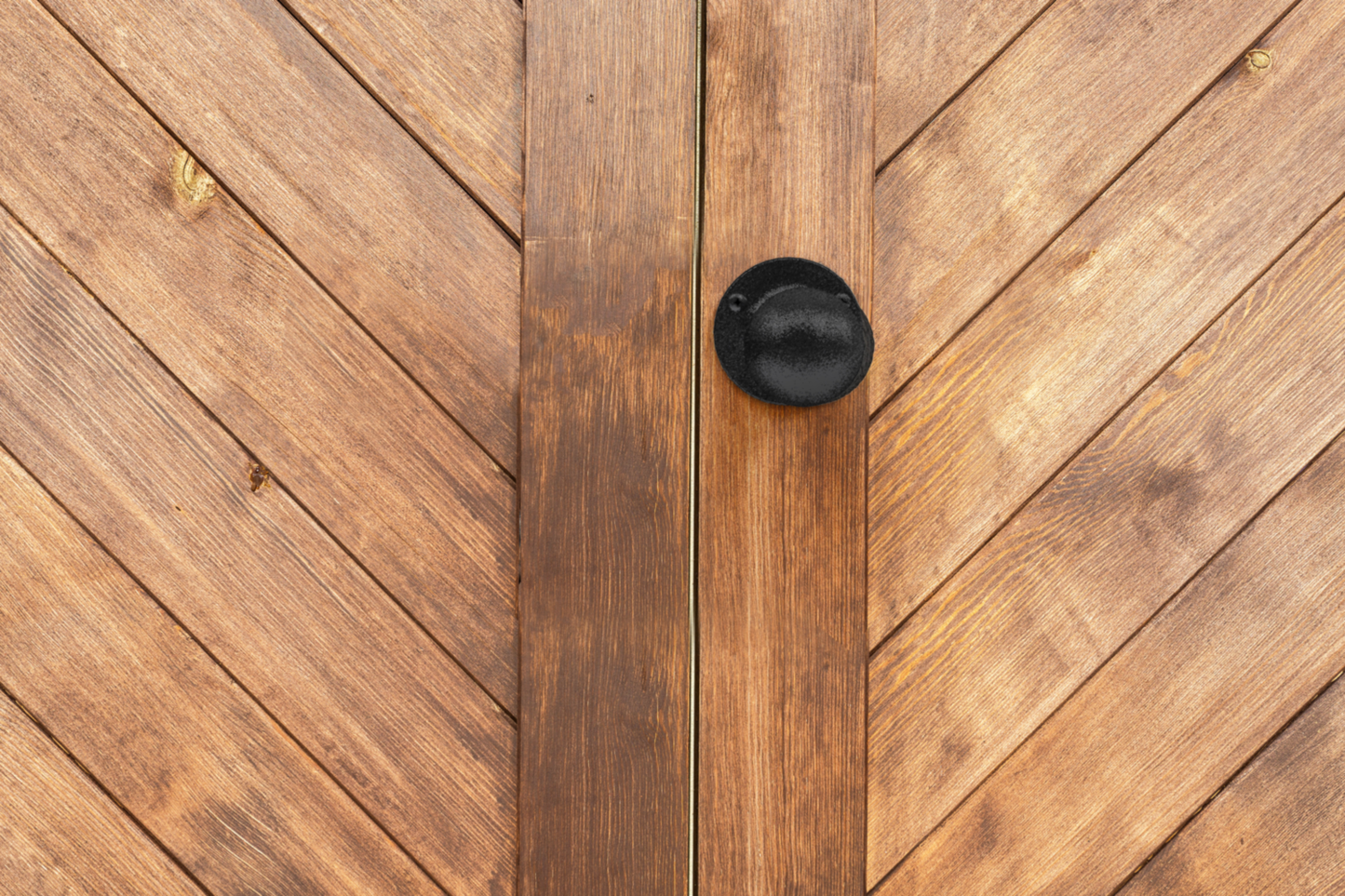 Black rounded gate knob mounted on textured wooden gate for door and gate hardware in home improvement tools under $50