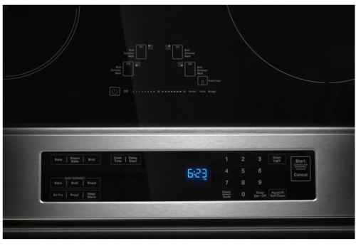 close-up of stainless steel induction range control panel with digital clock and multiple cooking function buttons