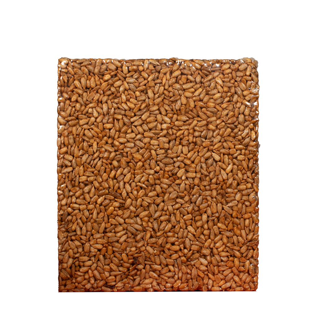 Rectangular compressed block of large brown sunflower seed cake for bird feeding in clear packaging