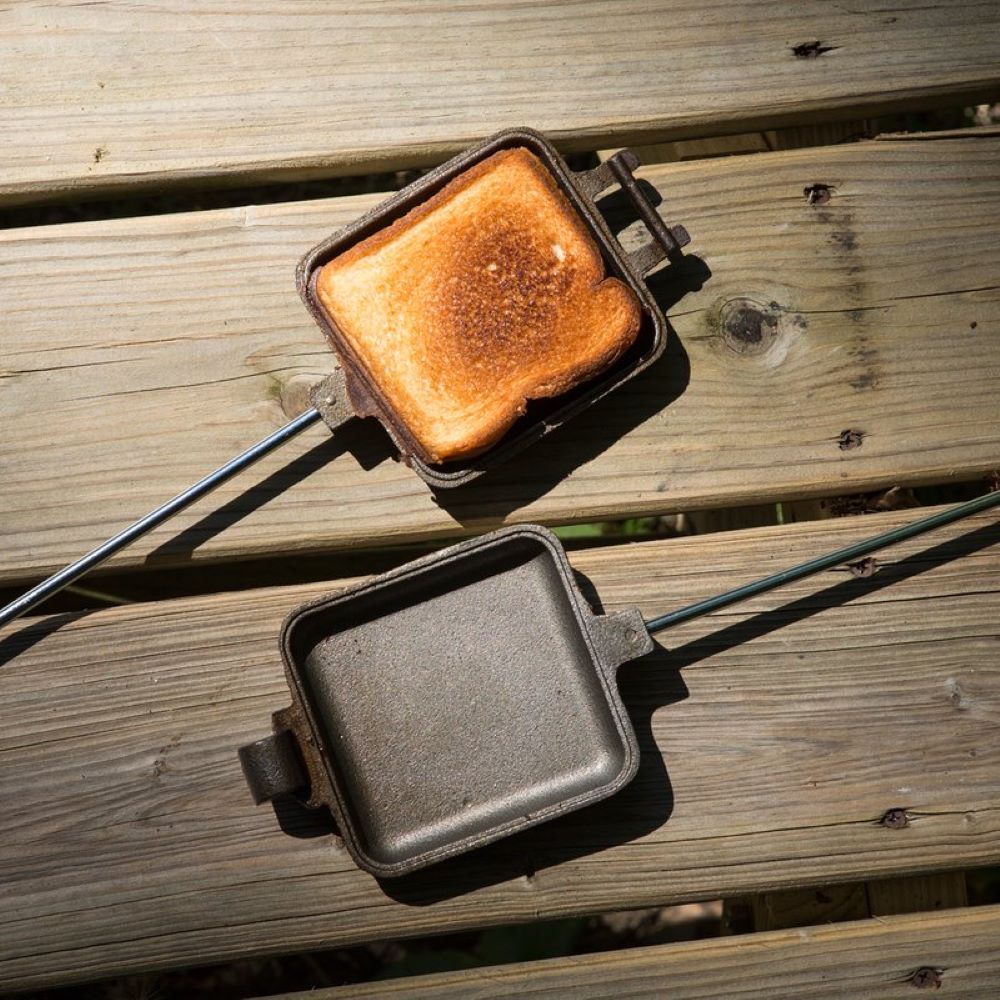 Square cast iron pie cooker with 27-inch handle toasting sandwich outdoors for grilling and kitchen use under 50 dollars