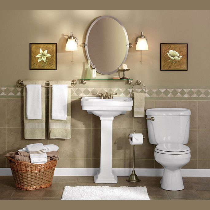 Oval brushed nickel tilting mirror mounted above a white pedestal sink in a stylish home improvement bathroom setting