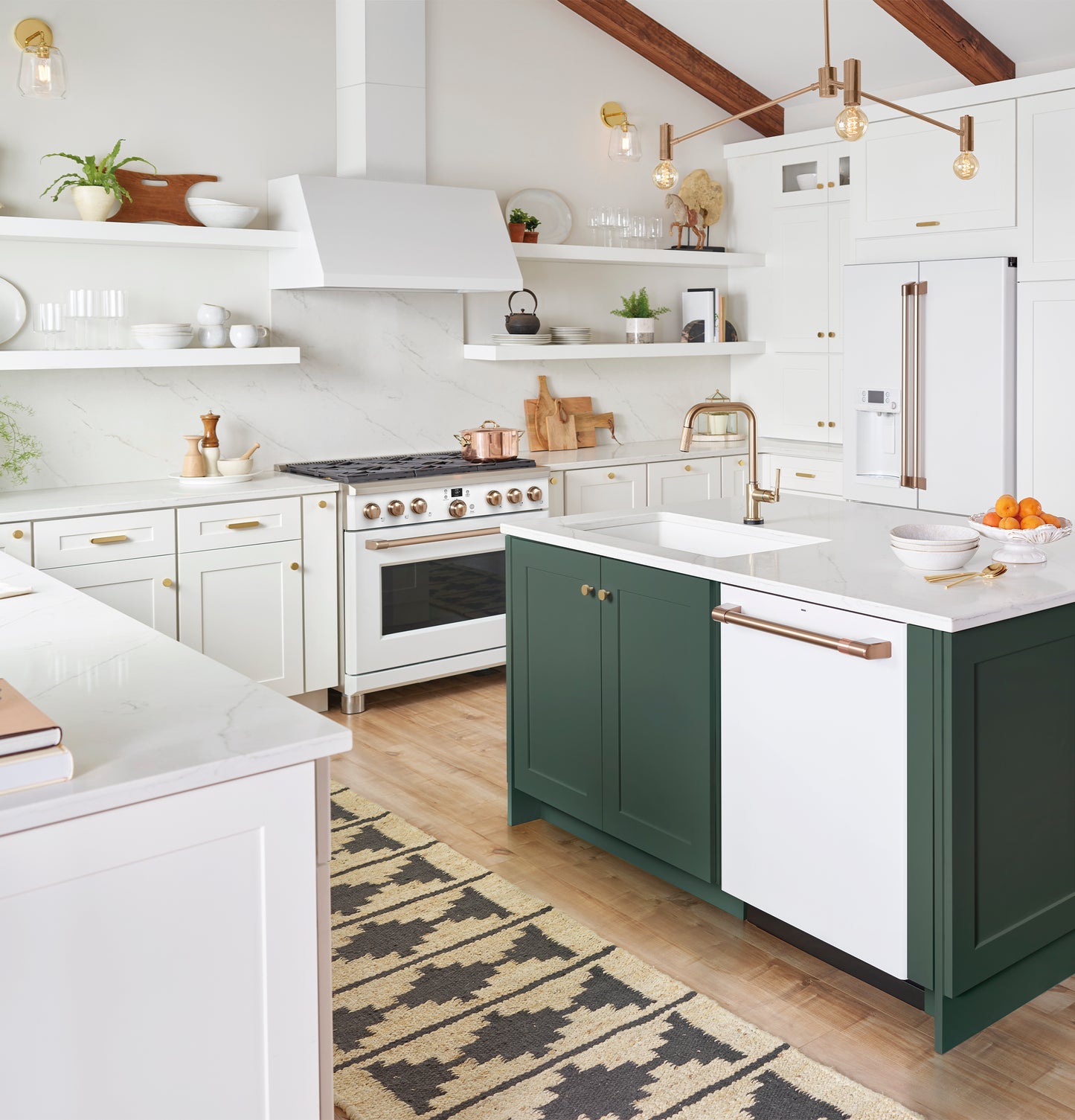 Bright modern kitchen featuring a white commercial style range hood above a stainless steel gas cooktop and green island cabinetry