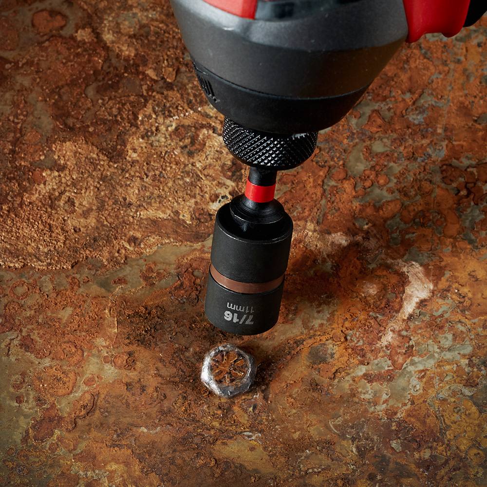 Close-up of drill with impact duty extractor removing stripped screw from rusted metal surface for home improvement use