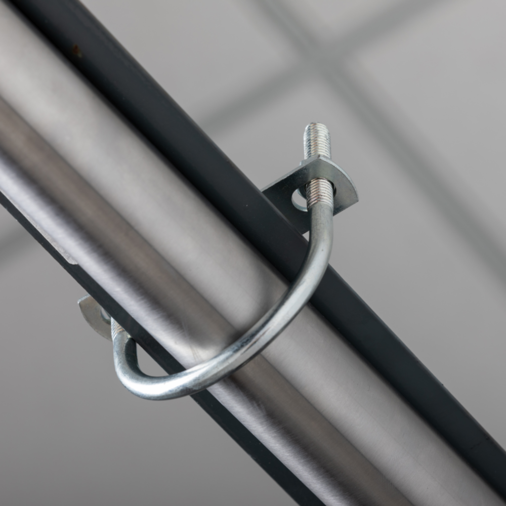 Zinc round U bolt securely fastening a pipe to metal framing in hardware and fastening collections