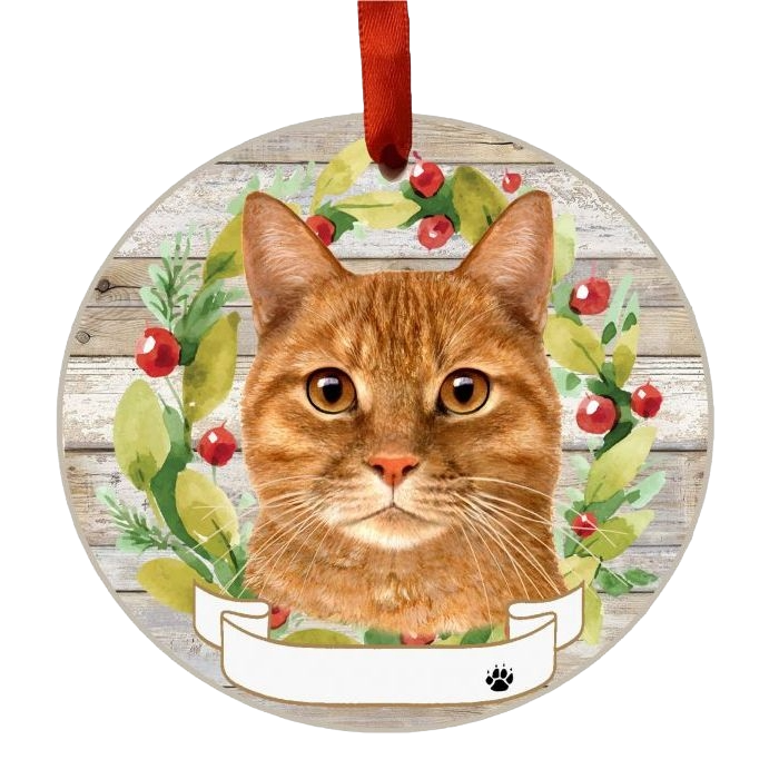 Round Christmas ornament with a detailed orange tabby cat face and a festive green and red wreath background