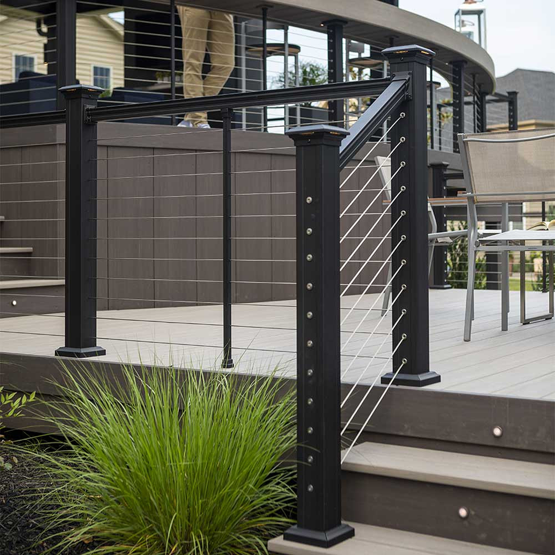 Black stair end post with horizontal cable railing for outdoor decking and home improvement projects