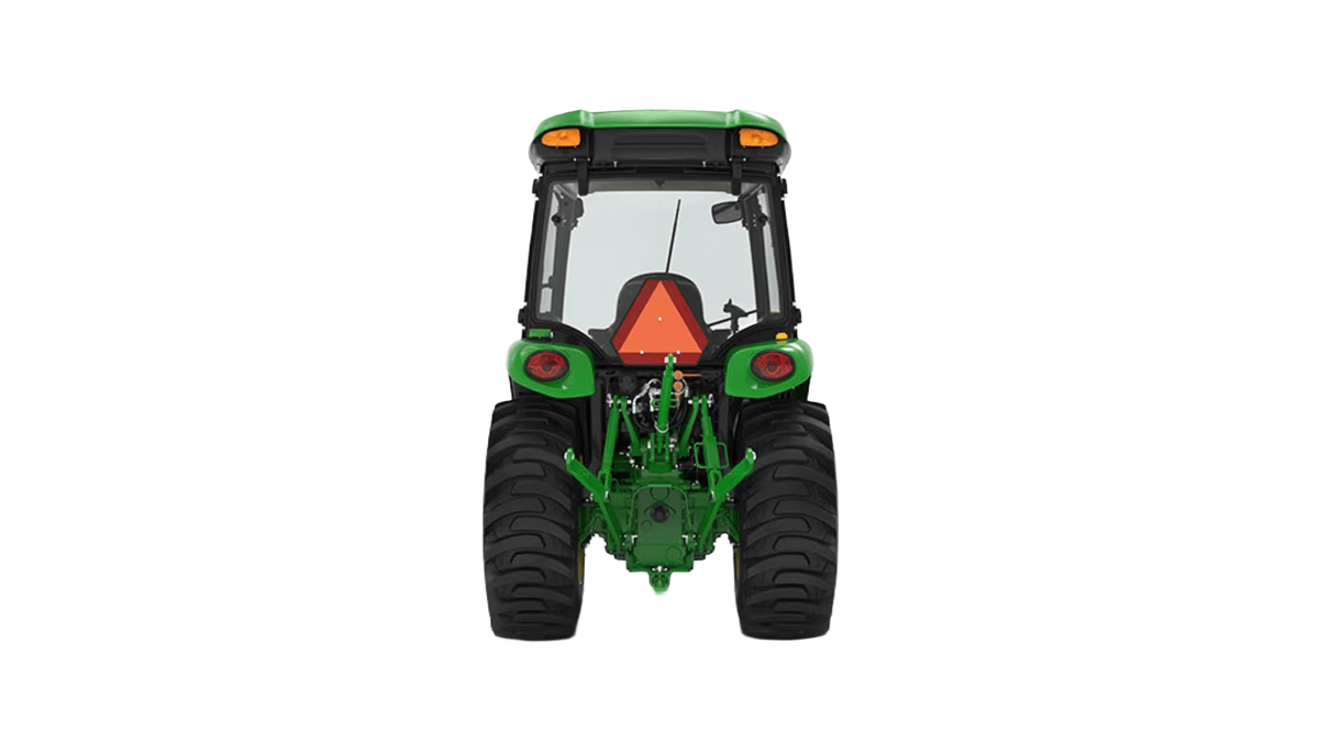 Rear view of green John Deere compact tractor with snow cab and standard seat for tools and home improvement tasks