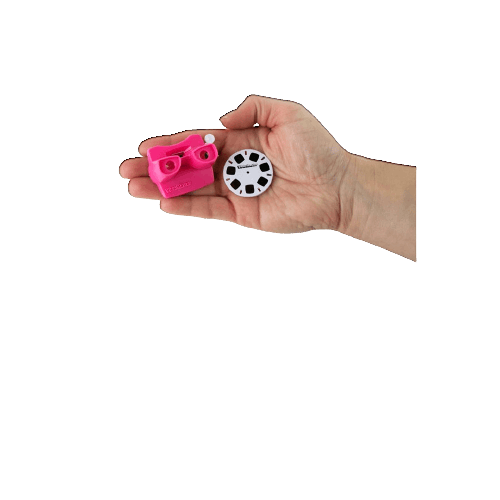 Hand holding a miniature pink Viewmaster toy and a small circular reel for viewing images