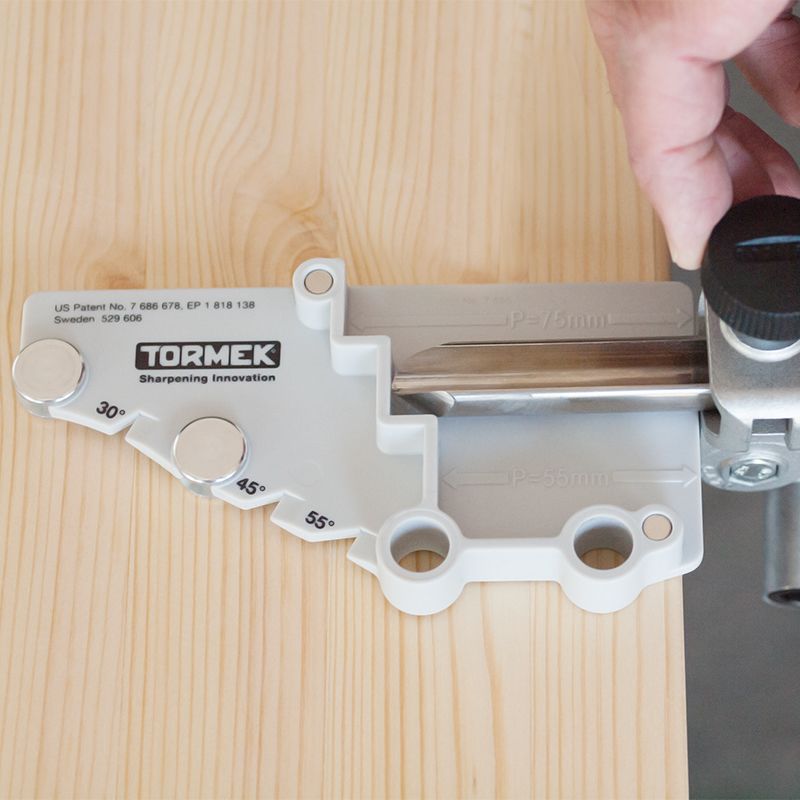 Hand adjusting silver and black tool setter with engraved angle markers for woodturning tool sharpening in woodworking tools collection