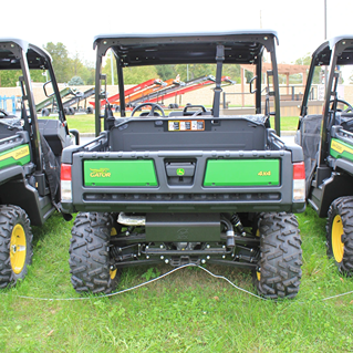 Rear view of green John Deere utility vehicle with 4x4 drivetrain and rugged off-road tires for heavy-duty outdoor use