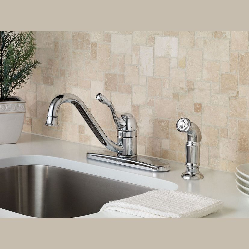 Chrome single-handle kitchen faucet with low arc pullout spout and side sprayer on white countertop in home improvement setting