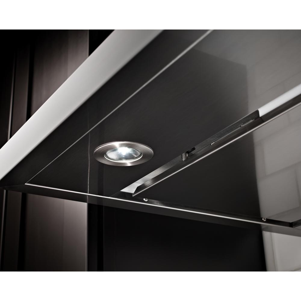 Close-up of a stainless steel canopy hood with built-in LED light and sleek modern controls in a kitchen setting