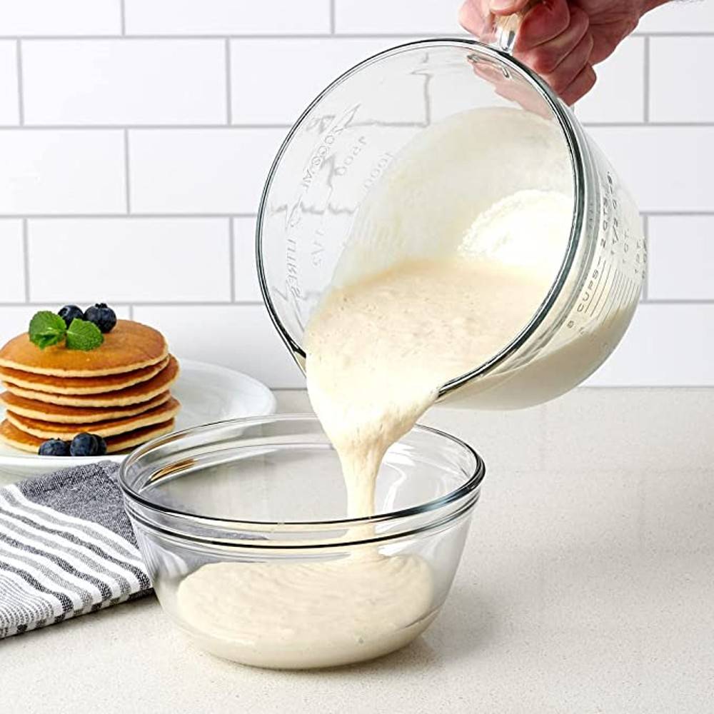 Glass batter bowl with handle pouring pancake mix into clear mixing bowl in kitchenware under $50 collection