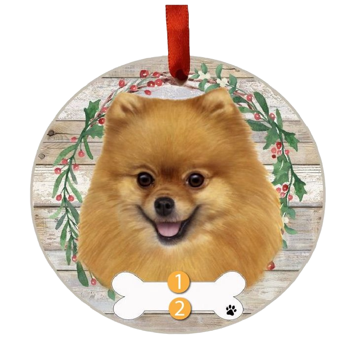 Round Christmas ornament featuring a happy Pomeranian face framed by a festive wreath and red hanging ribbon