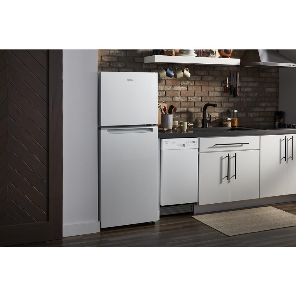 Compact white top freezer refrigerator in modern kitchen with brick backsplash and white cabinetry storage