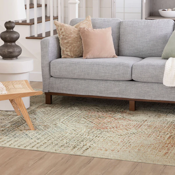 Ivory area rug with textured pathway design placed under modern gray sofa in stylish living room setting
